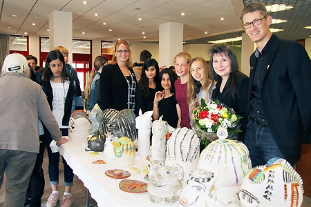 Schulleiter Tilman Latzel (von rechts), Edith Beck-Kowolik, Lilly Winnekens, Sophie Zobel, Sidra Alekloo, Fatema Jafari und Geschäftsstellenleiterin Kathrin Hüsch schauen sich die in der Sparkasse Alpen ausgestellten Keramiken an.