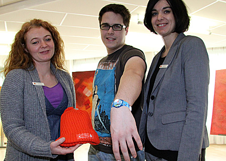 Molkereifachmann René Aust erhielt von Sandra Eiserich (links) und Kerstin Merker in der Geschäftsstelle der Sparkasse an der Poststraße in Neukirchen eine original Olympia-Uhr.