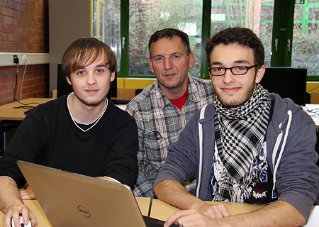 Christian Gläsner (l.) und Max Lukas-Nülle (r.) machen beim Planspiel Börse der Sparkasse am Niederrhein mit. Lehrer Reinhard Radtke betreut neben den beiden 17-Jährigen noch viele weitere Spielgruppen am Berufskolleg für Technik.