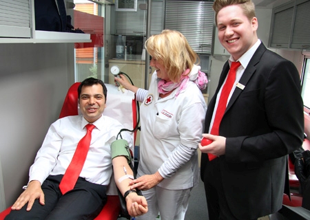 Das DRK-Blutspendemobil macht am 14. April zum dritten Mal Station an der Sparkasse in Moers. Das Bild ist aus dem vorigen Jahr und zeigt den Auszubildenden Dominic Kalberg (rechts) und den Vorstandsvorsitzenden Giovanni Malaponti mit Annette Strehlau vom DRK-Team.