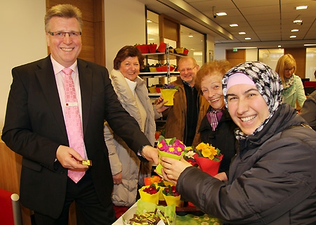 Blumen und Schokolade verteilten Detlev Moll (v.l.n.r.) und Margot Klein am Stand der Werbegemeinschaft in der Meerbecker Sparkasse. Die Kunden Rudolf Stenzel, Ursula Klinger und Fatma Yilmaz freuten sich sehr über die farbenfrohen Primeln.