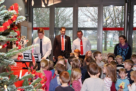 Die Kindergartenkinder schmückten den Baum in der Sparkassen-Geschäftsstelle Orsoy und sangen mit Azubi Dominic Kalberg (l.) bekannte Lieder. Von Norbert Kubik und Daniel Zvar bekamen sie Weckmänner und Trinkpäckchen. Auch Erzieherin Corine Peter (r.) genoss die kleine Weihnachtsfeier.