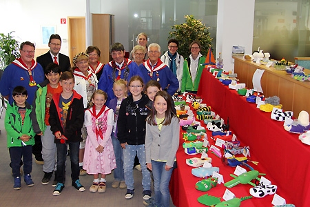 Klompenfreund-Vorsitzender Karl-Heinz Möhlendick (v.l.n.r.), Uwe Brans von der Sparkasse am Niederrhein sowie weitere Klompenfreunde und Lehrerinnen der Pestalozzischule freuen sich mit den Kindern über die schön arrangierte Ausstellung in der Geschäftsstelle Vluyn.