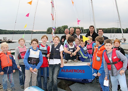 Mit dem Spendengeld der Sparkasse am Niederrhein konnte sich die Rheinberger Europaschule eine eigene Jolle kaufen. Die wurde jetzt am Lohheider See feierlich auf den Namen Albatross getauft. Mit den Kindern der Segel-AG freuten sich (hinten, v.l.n.r.) Lars Hinrichsen vom Förderverein, Artur Schedlinski von der Seglergemeinschaft, Vorstand Frank-Rainer Laake, Martin Reichert von der Europaschule und Sparkassenmitarbeiter Frank Tatzel.