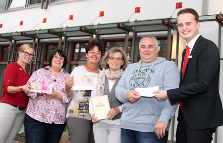 Die Sparkassenmitarbeiter Isabel Winn (l.) und Fabian Langenbach (r.) überreichen den Gewinnern Gabriele Becker, Brigitte Pugehl, Maria Meiwes und Oliver Möller Gutscheine über je 50 Euro.