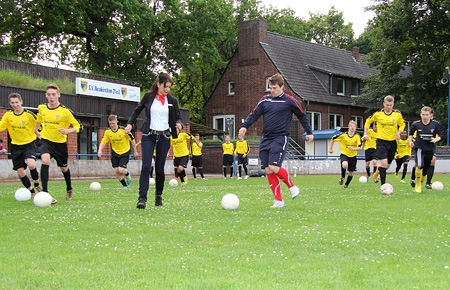 Kerstin Merker im Doppelpass mit Trainer Daniel Haak. Die Sparkassenfrau hatte den A-Junioren des JFV Neukirchen-Vluyn zum Trainingsauftakt neue Trikots mitgebracht.