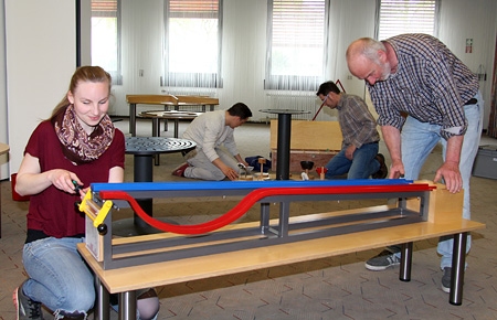 Laura Heß (l.) und Rolf Schubert (r.) bauen die 20 Stationen des Mini-Mathematikums auf. Den Angestellten des Gießener Mitmach-Museums halfen Oliver Flügge und Thomas Münker.