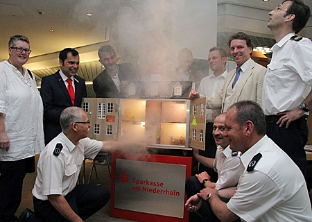 Zum Auftakt des Brandschutztages übergab Giovanni Malaponti (2.v.l.) das Rauchhaus an Feuerwehrchef Christoph Rudolph (ganz rechts) und Bürgermeister Christoph Fleischhauer (links daneben). Feuerwehrmann Achim Sörgel (vorne, links) zeigte, wie schnell sich das Treppenhaus mit Rauch füllt und den Bewohnern den Fluchtweg abschneidet.