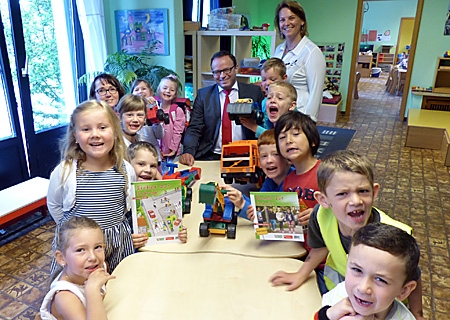 Sparkassenvorstand Frank-Rainer Laake (Mitte) schaute mit den Maxis der evangelischen Kindertagesstätte Orsoy in das Heft „Sicher zur Schule“, rechts neben ihm steht Kita-Leiterin Sabine Linster.