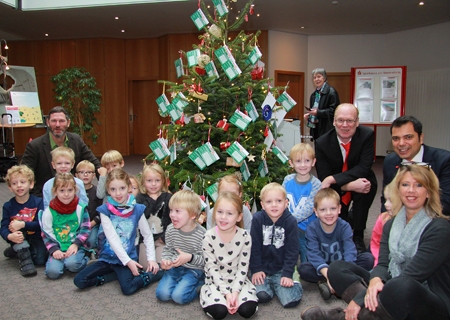 Die Kinder des evangelischen und katholischen Kinderkartens schmückten den Baum in Kapellen. Ganz links: Klartext-Geschäftsführer Michael Passon, ganz rechts: Gudrun Tersteegen vom Klartext Vorstand mit Giovanni Malaponti und Geschäftsstellenleiter Bernd Tersteegen. 