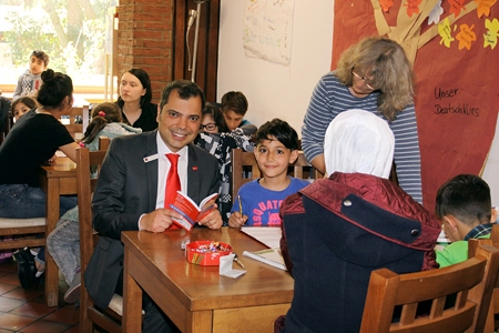 Sparkassenchef Giovanni Malaponti, der neunjährige Amar und die Lehrerin Anja Birk im Café Vielfalt, dem Treffpunkt des Netzwerkes Moers Mitte.