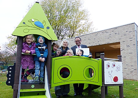 Sparkassenvorstand Frank-Rainer Laake und Kindergartenleiterin Ulla Czechan mit Kindern des katholischen Kindergartens St. Anna am neuen Spielturm. 