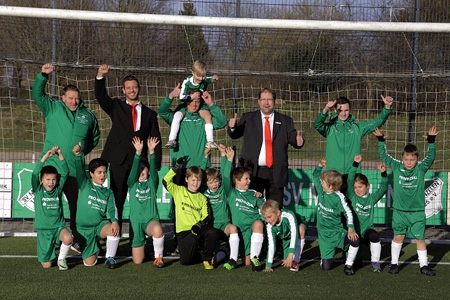 Trainer Marcus Kolodzy, Sparkassenmitarbeiter Fabian Felske, Trainer Ingo Dahlhoff, Geschäftsstellenleiter Volker Oppers und Co-Trainer Yannis Twardzik (v.l.n.r.) freuen sich mit den Mädchen und Jungen der F2- und F3-Kicker des SV-Menzelen über die neuen Trikots.