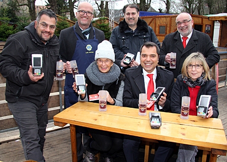 Schausteller und Lionsclubs setzen beim Glühweinverkauf erstmals Bezahlterminals ein (v.l.n.r.): Philip Traber, Lutz Hormes (Lions), Christine Aberfeld, Michael Birr, Giovanni Malaponti, Heiner Rütjes (Sparkasse) und Angelika Krause (Zajunz).