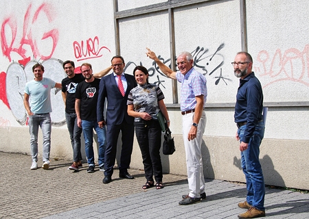 Die MAP-Festivalmacher Marco Kutz, Manuel Kutz und Philipp Rott, Sparkassenvorstand Frank-Rainer Laake, Edeltraud Hackstein und Norbert Nienhaus vom Stadtmarketing sowie Wirtschaftsförderer Thomas Bajorat stehen vor der Fassade an der Ecke Orsoyer Straße / Innenwall. Dort, wo im Mittelalter das Orsoyer Stadttor stand, werden ab Montag vier Künstler mit Sprayfarben ein Kunstwerk schaffen, dass die Geschichte Rheinbergs mit der Moderne verbinden soll und zukünftig die Besucher der Stadt freundlich willkommen heißt.