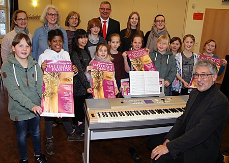 Hans-Hermann Buyken (rechts) brachte zur Probe ins evangelische Gemeindehaus Vluyn die ersten Plakate für die Matthäus Passion mit. Zusammen mit den Kindern und den  Chorleiterinnen Claudia Naujoks (2.v.l.) und Susanne Weber-Spickers (rechts daneben) sang sich Sparkassenvorstand Bernd Zibell mit ein. 