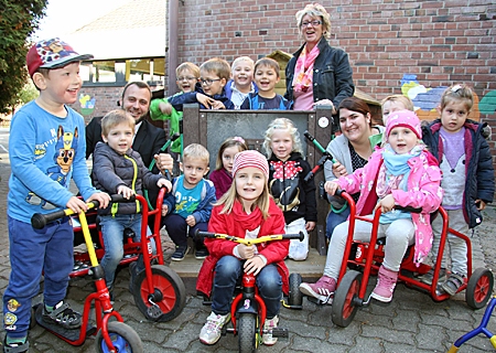 Annette Sturm freut sich mit ihren Kindern der evangelischen Kita in Schwafheim über die neue Tankstelle. Thomas Tietmann und Katrin Schwarz spielten die Tankwarte.