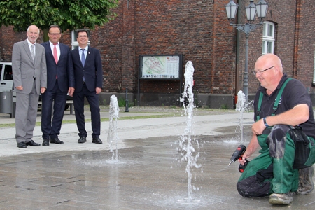 Hans Lüttke Dartmann von der Firma Aqua-Ko (r.) zog die letzten Schrauben an, danach nahmen Bürgermeister Frank Tatzel, Sparkassenvorstand Frank-Rainer Laake und der technische Beigeordneten Dieter Paus (v.r.n.l.) das neue Fontänenfeld auf dem Rheinberger Marktplatz offiziell in Betrieb.