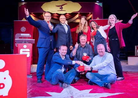 Sternstunde im Zirkus Lüttinelli der Hagelkreuzschule (v.l.n.r): Sparkassenvorstand Frank-Rainer Laake, Bürgermeister Thomas Görtz, Glücksfee Lea Baumgärtner, Fatma Aydin (Awo-Kindertagesstätte) und Claudia van Dyck, die Verwaltungsratsvorsitzende der Sparkasse. Vorne, von links: Christof Schneiderat (Tennisclub), Werner van Gemmeren (Blutwurstkomitee) und Moritz Bucher von der Fazenda da Esperanca.