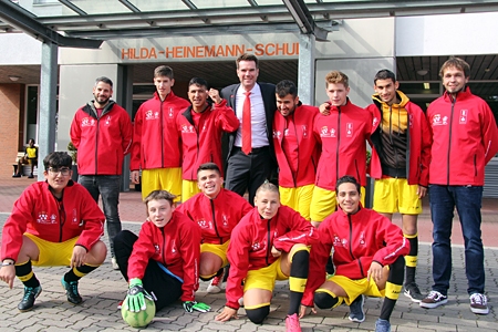 Die 14- bis 17-jährigen Fußballer der Hilda-Heinemann-Schule fahren mit ihren Lehrern René Hesen (hinten links) und Marc Schulz (rechts) zum Finale von ‚Jugend trainiert für Paralympics‘ in Berlin. Damit die Mannschat nicht nur gut spielt, sondern auch gut aussieht, wenn sie zur Eröffnungsfeier ins Olympiastadion einläuft, überreichte Stefan Ertelt, Marketingchef der Sparkasse am Niederrhein, die offiziellen T-Shirts und Trainingsjacken von ‚Jugend trainiert für Olympia'.