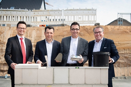 Thorsten Nossack von der Sparkasse am Niederrhein, der Geschäftsführer der ESA-Bauunternehmung, Samir Efendic, Bürgermeister Christoph Landscheidt und Dirk Götze, Marketingleiter der ESA, bei der symbolischen Grundsteinlegung für das Neubaugebiet „Wohnen an der Fossa“ in Kamp-Lintfort. Es sind nur noch wenige Eigentumswohnungen zu haben.
