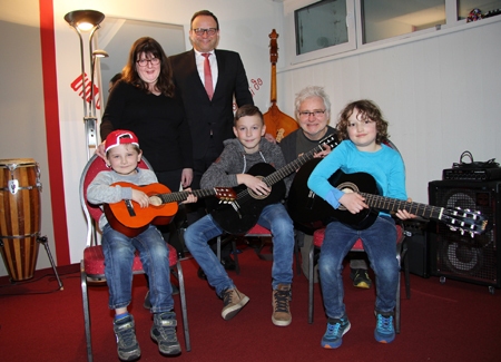 Der sechsjährige Julian Krupp (l.) zeigt eine der neuen Dreiviertel-Gitarren, die die Sparkasse am Niederrhein der Dom-Musikschule spendete. Schatzmeisterin Valérie Petit bedankte sich bei Vorstand Frank-Rainer Laake (Mitte), der bei seinem Besuch auch den neunjährigen Jonas Paaßen, Gitarrenlehrer Wolfgnag Reich und den sechsjährigen Finn Prüller kennenlernte.