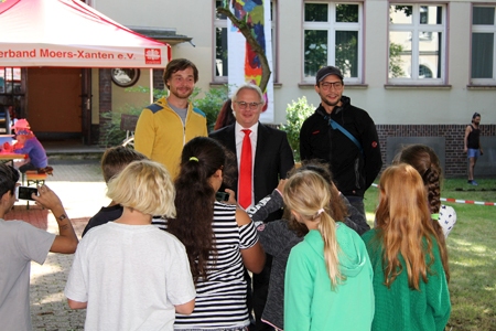 Die acht- und neunjährigen rasenden Reporter, interviewen Marco Kutz, Thorsten Holzgräfe und Manuel Kutz (v.l.n.r.). Beim PirARTLON rund um die ehemalige Maria-Montessori-Schule erleben 100 Grundschulkinder eine ganz besondere Kreativwoche mit vielen Workshops und Aktionen. Organisiert wird das PirARTLON von Caritas und MAP-Festival. Die Sparkasse am Niederrhein gibt eine Finanzspritze von 1.000 Euro.