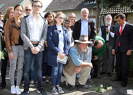 Rosa Cansever, Daniel Brachmaier und Christina Jasinski (vorne, von links) beschäftigten sich intensiv mit der Krankenakte und den Briefen, die vom Schicksal Helmut Schöns berichten. Dr. Bernhard Schmidt (dahinter) vom Verein „Erinnern für die Zukunft“ hatte den Kontakt zu den beteiligten fünf Schulen geknüpft und die Schülerinnen und Schüler mit Material aus der NS-Dokumentationsstelle versorgt, Gunter Demnig (Mitte, kniend) verlegte den Stolperstein, dahinter: Neffe Michael Schön. Ganz rechts: Giovanni Malaponti von der Sparkasse am Niederrhein.