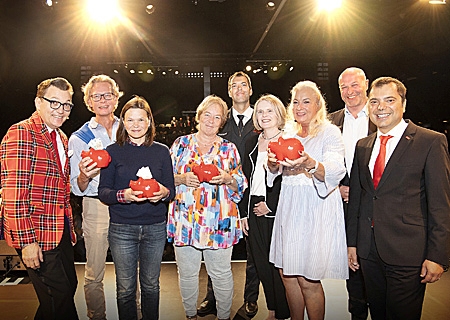 Die Verlosung von viermal 250 Euro Extra-Spenden übernahm Moderator und Musiker Markus Schimpp (ganz links). Giovanni Malaponti (ganz rechts) und Claudia van Dyck (4.v.rechts) überreichten sie an (v.l.n.r.): Stefan Nies (Netzwerk Mitte Moers) Doreen Prix (Förderverein Fechtsport), Marion Maas (Tanedi Kunstverein) sowie an Andre Cronenberg und Ute-Maria Schmitz (Förderverein Feuerwehr). Der stellvertretende Bürgermeister Ibrahim Yetim (2.v.r.) gratulierte herzlich. 