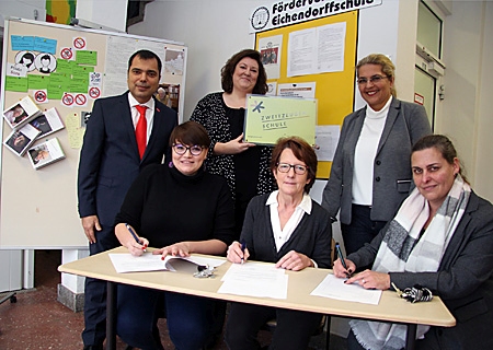 Vertragsunterzeichnung an der Eichendorffschule (v.l.n.r.): Giovanni Malaponti, Vorstandsvorsitzender der Sparkasse am Niederrhein, Vanessa Eisenhardt (Heimatsucher), Charlotte Fricke (Lehrerin und Heimatsucher), Ute Kampow (Schulleiterin), Nicole Wardenbach (Schulrätin) und Melanie Fröhlich (Schule) freuen sich über die bundesweit erste Kooperation einer Grundschule mit dem Verein Heimatsucher. 