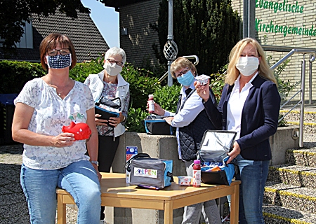 Von links nach rechts: Marlis Schug (Tafel in Alpen), Karin van Bonn (1. Vorsitzende des Kinderschutzbundes Alpen), Stefanie Lehmbrock (Kinderschutzbund) und Ruth Terfloth (Schatzmeisterin) packen Taschen mit gesunden Lebensmitteln vor dem evangelischen Gemeindehaus.