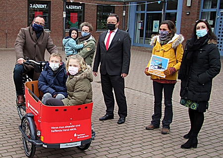 Lastenfahrrad fuer Hagelkreuzschule Xanten 1220 oben Übergabe des neuen Elektro-Lastenfahrrades der Stadt an die Familie Schreurs (v.l.n.r.): Bürgermeister Thomas Görtz mit Kalle und Ida (vorne). Hinten (v.l.): Vanessa Schreurs mit Peter, Sparkassenvorstand Frank-Rainer Laake, Klimaschutzmanagerin Dr. Lisa Heider und Daniela Hommen, Leiterin der Hagelkreuzschule.