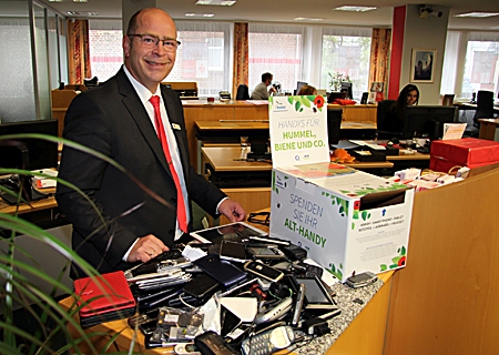 Carsten Fröhlich, Vorstandsmitglied der NABU-Kreisgruppe Wesel, mit einer Sammelbox für alte und defekte Handys. „In jeder Geschäftsstelle der Sparkasse am Niederrhein können Altgeräte abgegeben werden“, sagt der Naturschützer. Seit Beginn des Jahres kamen so von Moers bis Xanten bereits mehr als 800 Geräte zusammen.