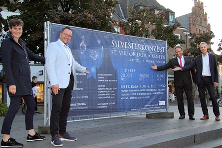 Heike van Baal, Geschäftsführerin der Tourist Information Xanten, Bürgermeister Thomas Görtz, Sparkassenvorstand Frank-Rainer Laake und der musikalische Leiter, Lucius Rühl, freuen sich auf das Silvesterkonzert im Xantener Dom.