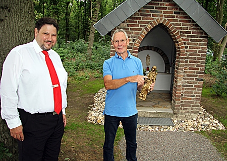 Heinz-Joachim Empelmann (rechts) berichtet Julian de Vries, Teamleiter der Sparkassen-Geschäftsstelle Millingen, von der Renovierung des Heiligenhäuschens und davon, wie er den Kopf des Jesuskindes wieder angeklebt hat. 