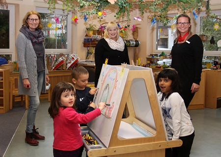 Das neue Staffelei-Center begeistert die Kinder der St.-Nikolaus-Kita in Veen. Leiterin Beate Sackers (v.l.n.r.), Anja Scholz vom Elternbeirat und Kathrin Hüsch von der Sparkasse am Niederrhein, die den Kauf der Kreativ-Station ermöglichte.