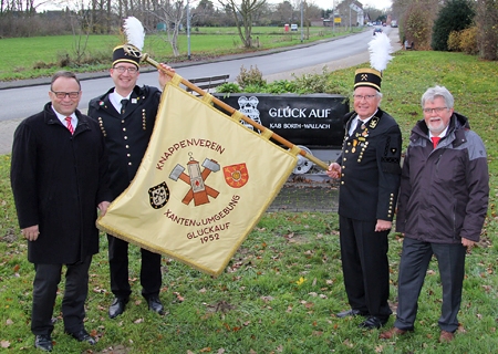 Lutz Wienen (2. v.l.) und Ronald Hoffmann vom Knappenverein Xanten und Umgebung Glückauf 1952 präsentieren vor der Lore am Schwarzen Weg die restaurierte Tragefahne. Die beiden Bergmänner bedankten sich bei Vorstand Frank-Rainer Laake (l.) und Geschäftsstellenleiter Heinz Geßmann für die 700-Euro-Spende der Sparkasse am Niederrhein.