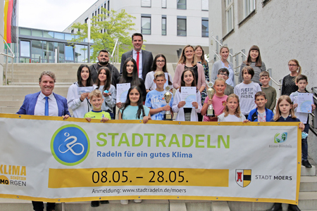 Bürgermeister Christoph Fleischhauer (l.) und Stefan Ertelt (oben) von der Sparkasse am Niederrhein zeichneten die besten Schulteams beim Stadtradeln aus. Die Schülerinnen und Schüler freuten sich über Pokale, Urkunden und Sonderpreise im Gesamtwert von 700 Euro.