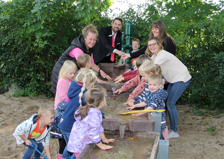 Die neue Matschanlage ist die Hauptattraktion im neu gestalteten Außenbereich des Labbecker St.-Georg-Kindergartens. Darüber freuen sich Lydia van Gemmeren (v.l.n.r.), Markus Hans, Jennifer Janssen und Karina Quinders.