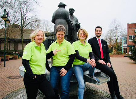 Die Sonsbecker Landfrauen Ute Fürtjes-Janßen, Ulrike Terhorst und Brigitte Krebber-van Betteray tragen die neuen Poloshirts beim Treffen mit Markus Hans von der Sparkasse am Niederrhein am Schweinebrunnen.