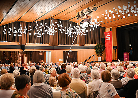 Rund 400 Gäste fühlten sich beim Sparkassen-Seniorenherbstfest pudelwohl. Drei Stunden lang wurde viel gelacht, geklönt und getanzt. Bei der komödiantischen Stangen-Akrobatik von Noah (unter der Decke) stockte manchen Besuchern aber auch schon mal der Atem.