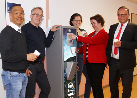 Auf dem Gang vor der Mensa des Amplonius-Gymnasiums steht jetzt ein Wasserspender. Schulleiter Marcus Padtberg (v.l.n.r.), KWW-Geschäftsführer Georg Tigler, Inge Ahrweiler und Annette Sandmann vom Förderverein sowie Frank-Rainer Laake von der Sparkasse am Niederrhein bei der offiziellen Inbetriebnahme des Geräts.