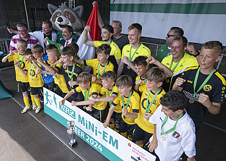 Sparkassen-Chef Giovanni Malaponti (hinten, 3.v.l.) jubelt mit dem Finalsieger der Mini-EM in Moers, der E-Jugend des VfB Homberg, die unter der Flagge Italiens spielte.