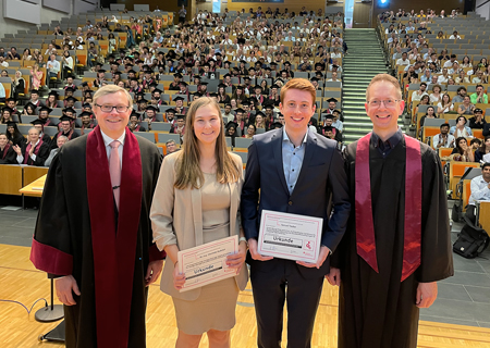 Professor Tobias Bruckmann (r.) verlieh vor rund 500 Gästen im Audimax die Innovationspreise Ingenieurwissenschaften der Sparkasse am Niederrhein an Dr. Charlotte Rudolph und Samuel Tauber. Professor Alexander Malkwitz (l.) gratulierte herzlich.