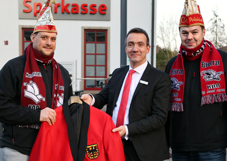 Marcel Weyhofen (l.) ist neu im Alpener Elferrat und freut sich über seine neue Anzugjacke. Präsident Björn Niedrig (r.) bedankte sich bei Geschäftsstellenleiter Tim Rütters für die 250-Euro-Spende der Sparkasse am Niederrhein.