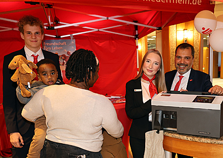 Gute Stimmung am Weltspartags-Schalter (v.l.n.r.): Fabian Menzel, der kleine Aaron mit seiner Mutter und dem Bruder Joschua sowie Lia Siefke und Giovanni Malaponti.