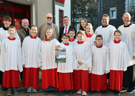 Die Menzelener Messdiener zeigen den Fotokalender, von dem Hans-Josef Angenendt (hinten, 3.v.l.) insgesamt 220 Stück verkaufen konnte. Den Erlös stockte die Sparkasse am Niederrhein mit einer Spende auf. Der Heimatfotograf konnte gemeinsam mit Geschäftsstellenleiter Tim Rütters (hinten, 4.v.l.) insgesamt 1.507,20 Euro an Pastor Dietmar Heshe (hinten, 2.v.l.). übergeben. Damit ist der diesjährige Tagesausflug der Messdiener gesichert.