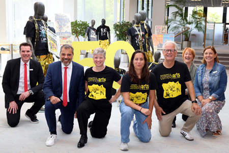 Eine Ausstellung zum Hinknien. Zum 50-jährigen Bestehen des ComedyArts-Festivals sind in der Sparkasse am Ostring viele Erinnerungsstücke und Fotos zu sehen. V.l.n.r.: Stefan Ertelt und Giovanni Malaponti von der Sparkasse, Wenke Seidel und Lili Schleyken vom Bollwerk107, künstlerischer Leiter Stefan Basso sowie Carmen Müller und Renate Stoppa von der Sparkasse.