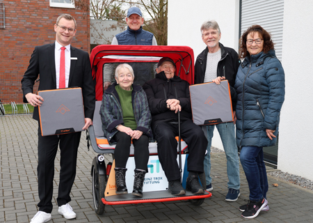 Sabine Suhr (von rechts), Willi Ehrmann und Frank Suhr von der Initiative ‚Radeln ohne Alter’ freuen sich über die 500-Euro-Spende der Sparkasse am Niederrhein, die Geschäftsstellenleiter Christopher Großheim (links) offiziell übergab. Damit konnten nun auch die letzten der insgesamt zwölf Fahrrad-Rikschas mit beheizbaren Sitzkissen ausgestattet werden.